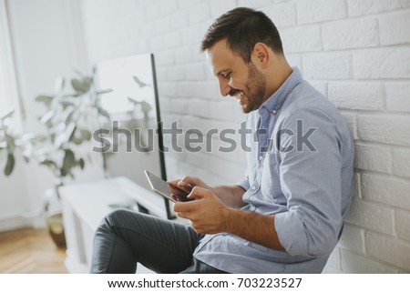 Stock photo: Happy Man Browsing In A Tablet Sitting On Commode At Home