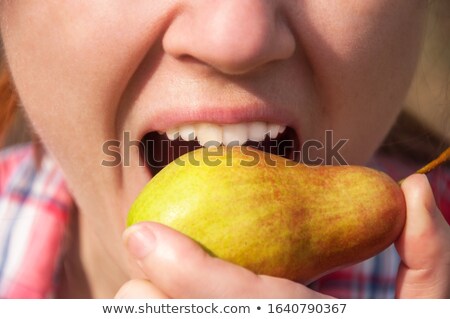 Zdjęcia stock: Young Woman Biting From A Yellow Pear