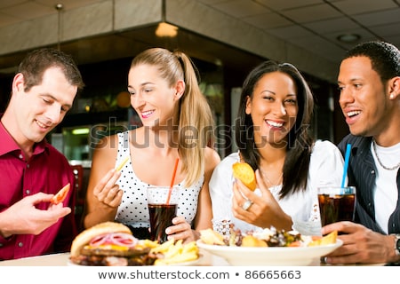 Foto d'archivio: Friends Or Couple Eating Fast Food With Burger And Fries