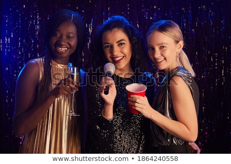 Stock fotó: Three Smiling Women Dancing And Singing Karaoke