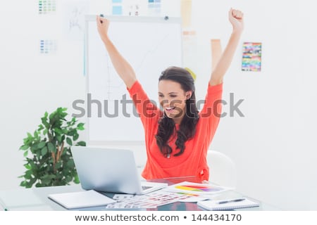 Stock photo: Excited Woman Raising Her Arms While Working On Her Laptop