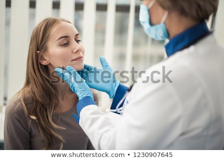 Stockfoto: Doctor Examining Patient Throat At Clinic