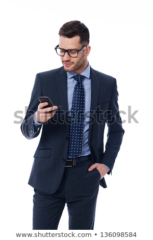 Foto d'archivio: Smiling Businessman Wearing Suit Holding Mobile Phone