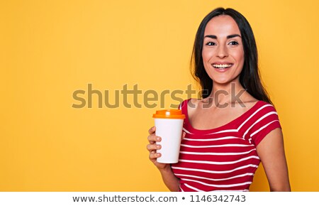 Stockfoto: Happy Cute Young Woman Posing Isolated Over Yellow Background Holding Cup Of Coffee