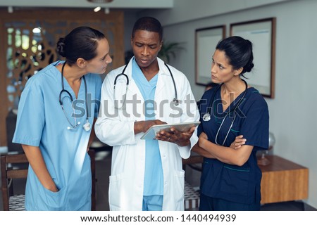 Stock foto: Front View Of Multi Ethnic Doctors Discussing Over Digital Tablet In Clinic At Hospital