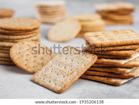Foto stock: Stack Of Square Organic Crispy Wheat And Corn Flatbread Crackers With Sesame And Salt On Light Backg