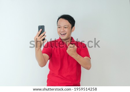 Foto stock: Asian Young Man Happy And Smile When He See On Smart Phone With Laptop Beside It Indonesian Man Wea