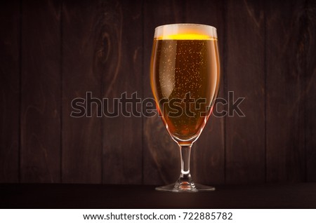 Stok fotoğraf: Goblet Beer Glass With Golden Sparkling Lager On Dark Wood Board Vertical