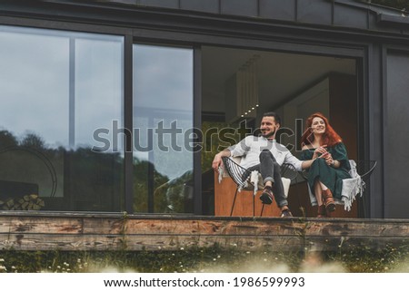 Stock fotó: Emotional Excited Young Loving Couple Sitting Outdoors In Evening In Christmas Hat Holding Gift Box