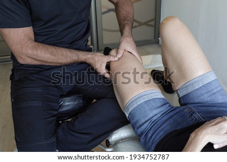 Stok fotoğraf: Anonymous Doctor Massaging Knee Of Patient
