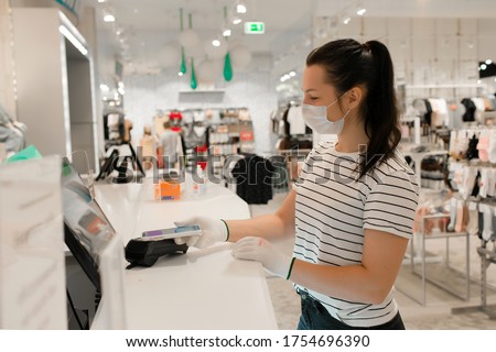Stock photo: Woman In A Clothing Store In A Medical Mask Because Of A Coronovirus Quarantine Is Over Now You Ca