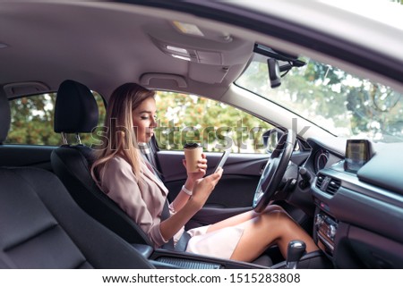 [[stock_photo]]: Pretty Young Woman Using Her Smart Phone While Driving Her Car