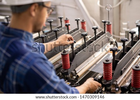Industrial Equipment Being Operated By Young Professional Technician Or Engineer 商業照片 © Pressmaster