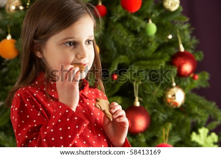 Stock photo: Young Girl Eating Star Shaped Christmas Cookie In Front Of Chris