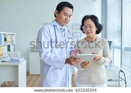 ストックフォト: Asian Cardiologist Analyzing Electrocardiogram