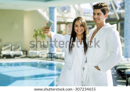 ストックフォト: Couple In Love Standing Next To A Pool In A Robe