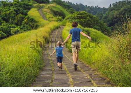 Foto stock: Dad And Son Tourists In Campuhan Ridge Walk Scenic Green Valley In Ubud Bali Traveling With Child