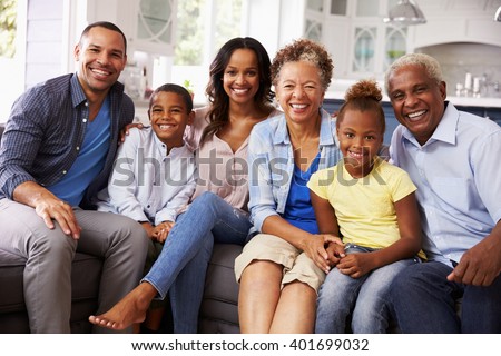 Foto stock: Front View Of A Happy African American Multi Generation Family Reading A Story Book In Living Room A
