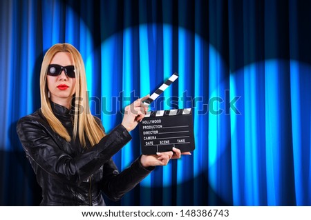 Stock photo: Girl With Movie Board Against Curtains