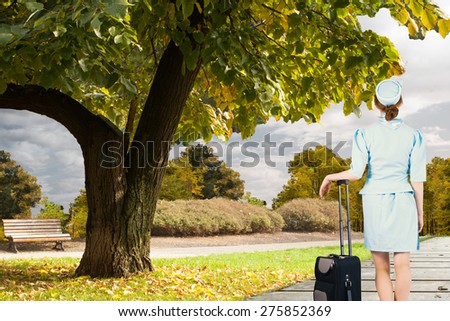 Foto stock: Composite Image Of Pretty Air Hostess Leaning On Suitcase