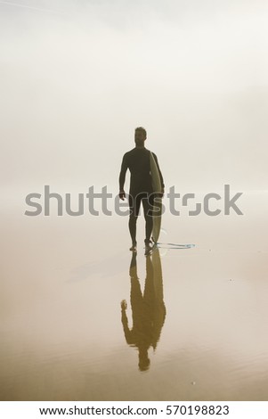 [[stock_photo]]: Young Man Ready For Surfing On A Misty Morning