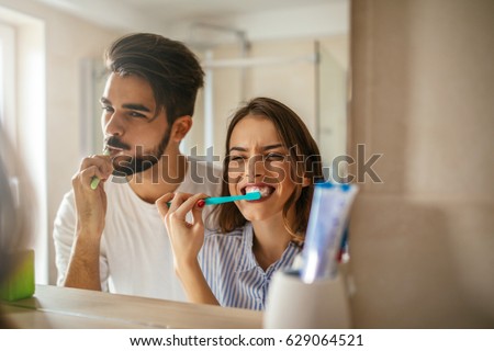 Foto stock: Young Couple Brushing Teeth