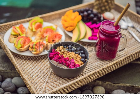 Stockfoto: Breakfast On A Tray With Fruit Buns Avocado Sandwiches Smoothie Bowl By The Pool Summer Healthy
