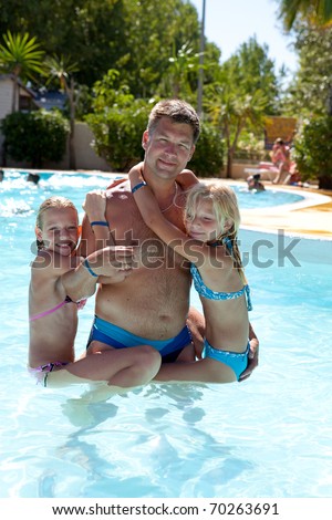 [[stock_photo]]: Father And Daughters Heaving Fun In The Swim Pool