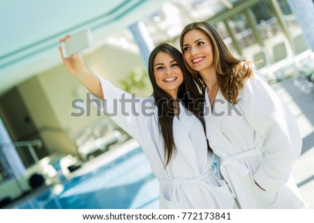 Stock photo: Two Attractive Ladies Taking A Selfie Next To A Swimming Pool