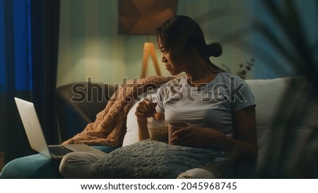 Сток-фото: Relaxing Ethnic Woman Eating Noodles And Watching Laptop