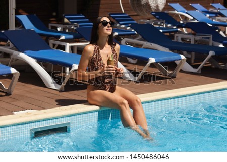 Foto d'archivio: Attractive Young Girl Sitting On The Edge Of A Glass Glamorous