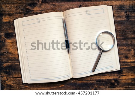 Foto stock: Business Appointments Agenda Notebook With Pencil And Loupe