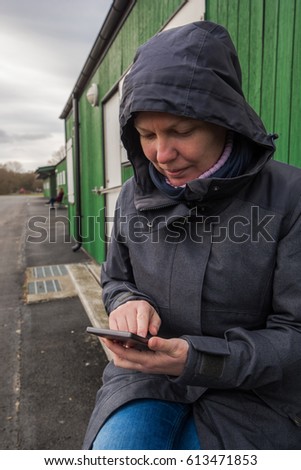 Stockfoto: Authentic Woman In Winter Jacket Typing Sms Message Outdoors