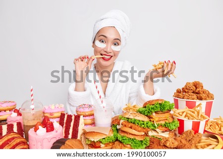 Foto stock: Joyful Asian Woman With Appetizing Doughnuts
