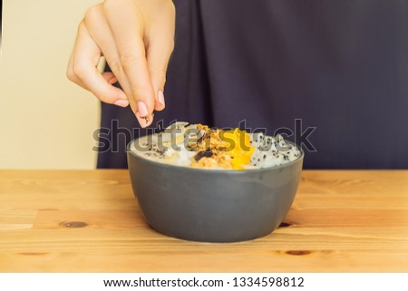 Foto stock: Woman Cooks Smoothie Bowls Made With Mango Banana Granola Gra