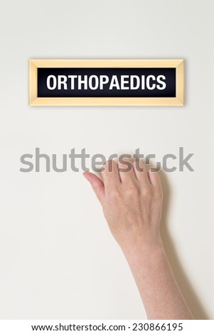 Foto stock: Female Hand Is Knocking On Orthopaedic Door