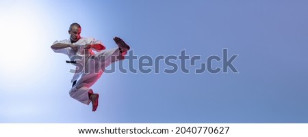 Stock photo: Sporty Young Man In Flying Martial Arts Pose