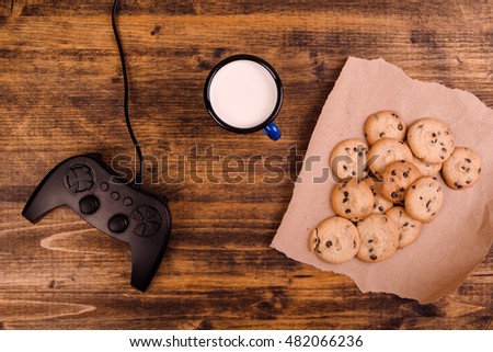 Stockfoto: Gamepad And Homemade Chocolate Chip Cookies On Rustic Wooden Tab