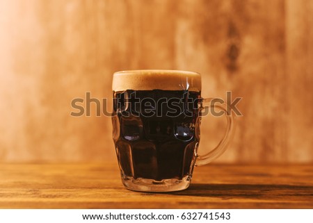 Foto stock: Dark Craft Beer In British Dimpled Glass Pint Mug