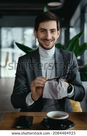 Foto stock: Optician Man Cleaning A Pair Of Eyeglasses