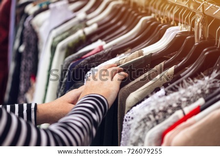 Stok fotoğraf: Woman Browsing Through Clothing At Second Hand Street Market