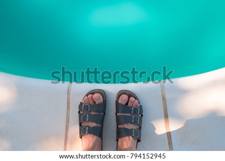 Foto stock: Bare Male Feet In Slippers By The Poolside