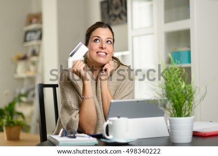 Stock fotó: Woman Holding Credit Card And Day Dreaming Before Online Shopping On Her Laptop At Home