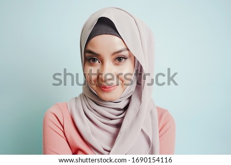 Stock photo: Portrait Of Beautiful Serious Young Muslim Woman Wearing Black Hijab With Hands Near Her Face As Pra