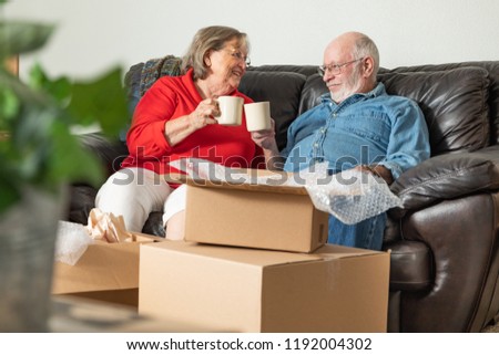 Stockfoto: Tired Senior Adult Couple Resting On Couch With Cups Of Coffee S