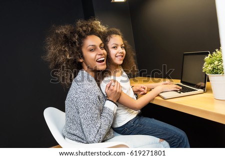 Foto stock: Happy African American Mother And Her Cute Daughter Using Digital Tablet On Bed In Bedroom At Home