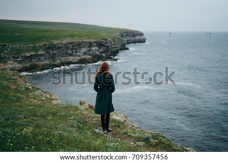 Stock photo: Side View Of A Beautiful Woman Standing On The Rock And Revitalizing At Beach On A Sunny Day