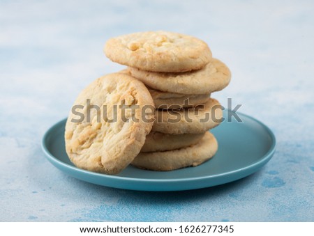 Stock fotó: White Chocolate Biscuit Cookies On Blue Ceramic Plate With Tea Pot And Cup On Blue Kitchen Table Bac