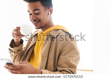 Stock photo: Photo Of African American Man Using Earpods And Drinking Water