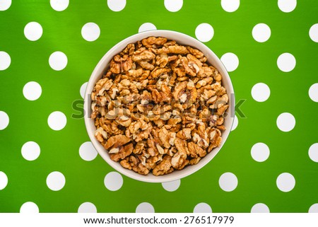 Stockfoto: Walnut Kernels In Bowl On Polka Dotted Background